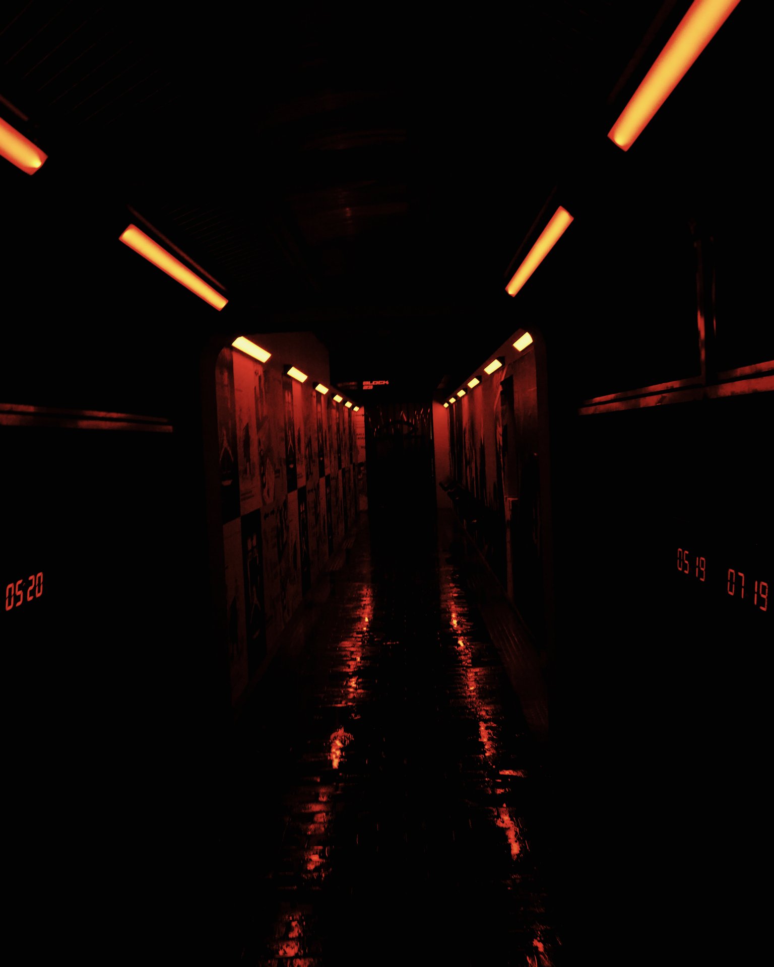 Red-lit hallway lined with posters and photos from Human Register's history