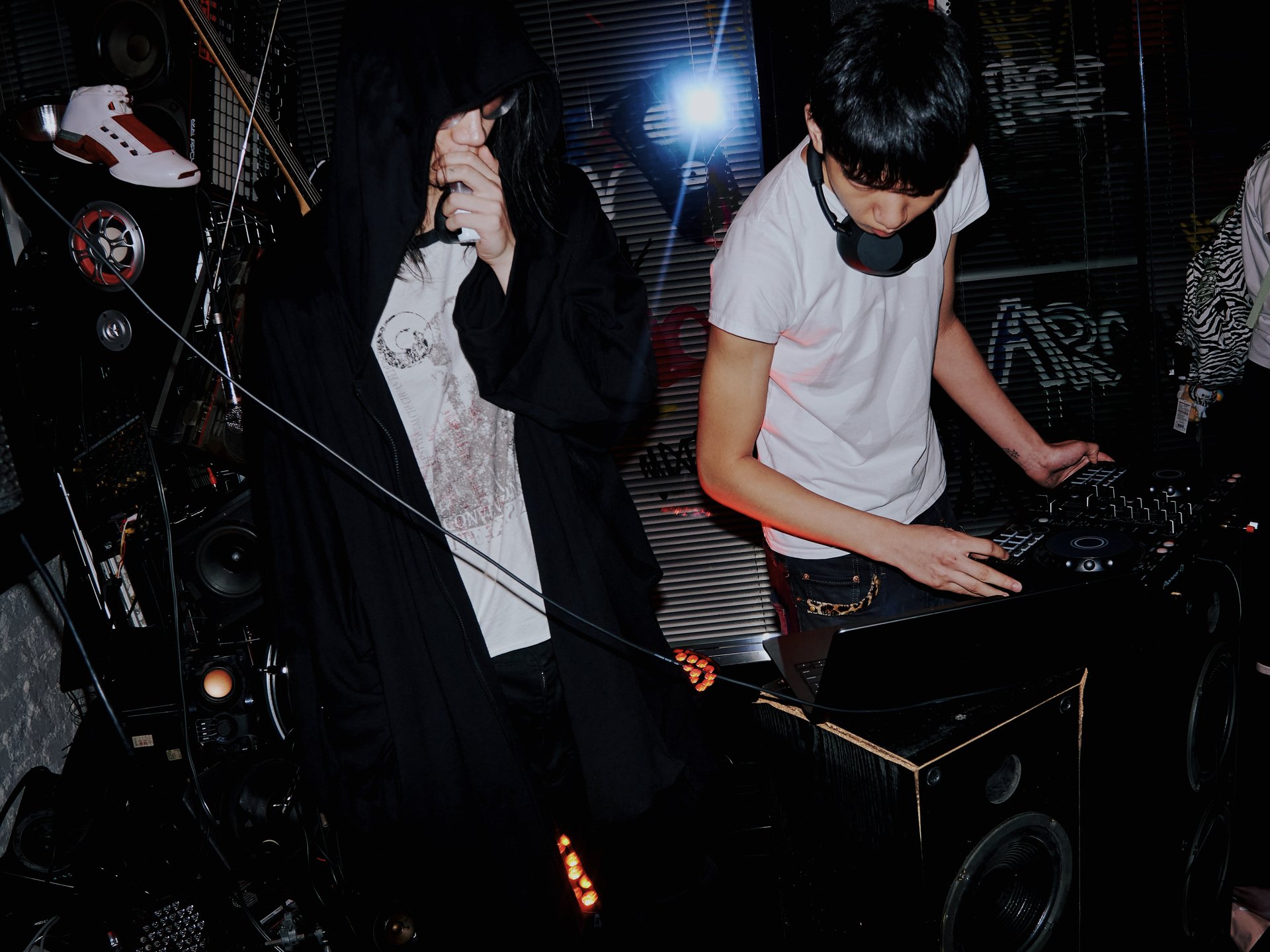 Live set with microphone and DJ mixer beside a wall of speakers